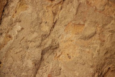 Kahverengi ve bej tonlarıyla desenli kumlu bir yüzeyin yakın görüntüsü.