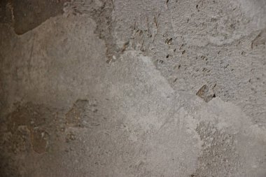 Gri ve karmaşık desenlerin çeşitli tonlarıyla desenli beton duvar yüzeyi.