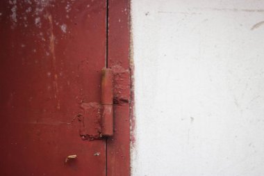 Kırmızı ve beyaz bir duvarın paslı kapı mandalına yakın çekim.