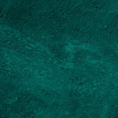 Textured teal surface with a subtle pattern and natural variations in color and tone.