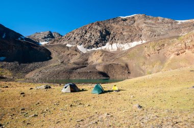 Dağ geçidinde kamp yapan bir grup yürüyüşçü. Tırmanışçılar, Sary Chelek Gölü, Sary-Chelek Celal Abad Bölgesi, Kırgızistan, Orta Asya 'da Trek gezisi yakınlarında çadır kurdular..