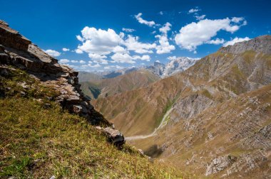 Dağların tepesindeki yüksek manzaralı Rocky geçidi. Sary Chelek Gölü, Sary-Chelek Celal Abad bölgesi, Kırgızistan, Orta Asya 'da yürüyüş yapan genç erkek ve kadınlar.