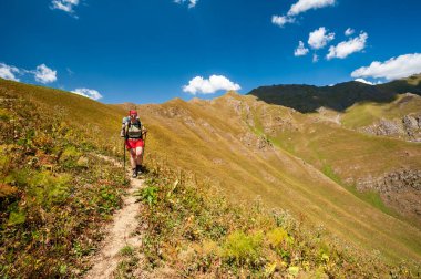 Female Hiker. Young woman alone trekking and backpacking in high mountains near Sary Chelek lake, Sary-Chelek Jalal Abad region, Kyrgyzstan, Trekking in Central Asia.