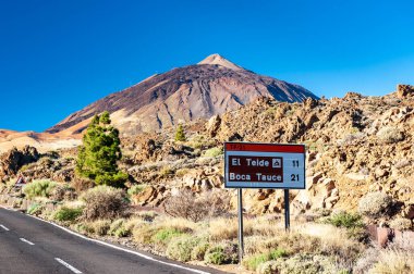 Volkan del Teide 'nin silueti ve mavi gökyüzüne karşı işaret direği. El Teide Ulusal Parkı 'ndaki Pico del Teide Dağı. Tenerife, Kanarya Adaları, İspanya