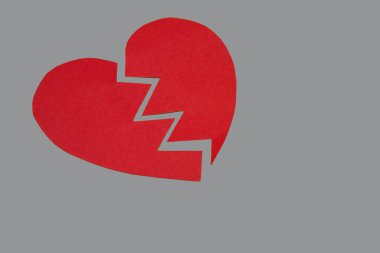 Gri arkaplanda iki parça kağıt kalp. Ayrılma ve boşanma kavramı. Kırmızı karton kalp..