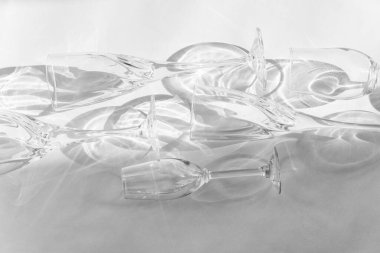 Boş bardaklar gri arkaplanda duruyor, üst görünümde. Siyah ve beyaz görüntü..