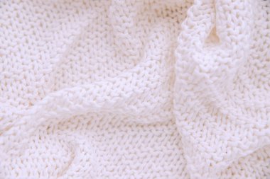 Sıcak örülmüş beyaz renkli battaniye. Battaniye düz olmayan dalgalarda yatıyor. Kış ya da sonbahar arkaplan ve dokusu.