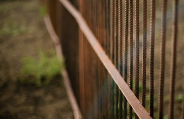 Çitlerden toplanan paslı demir parmaklıklar. Bahçe arsaları arasındaki sınır. Grafiksel paralel çizgiler. Eski metalin yapısı ve dokusu.