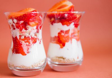 Sağlıklı bir kahvaltı taze meyve, yoğurt ve müsli ile hazırlanır. Tatlı şeffaf yakın plan gözlüklerle katmanlar halinde düzenlenir. Beslenme hafif yemeği.