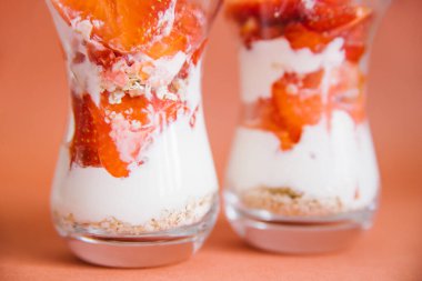 Sağlıklı bir kahvaltı taze meyve, yoğurt ve müsli ile hazırlanır. Tatlı şeffaf yakın plan gözlüklerle katmanlar halinde düzenlenir. Beslenme hafif yemeği.