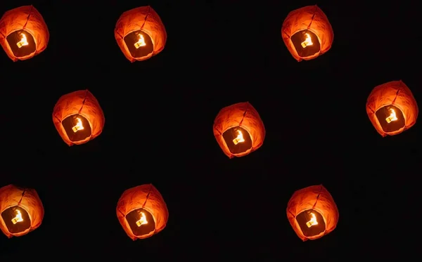 Paper lanterns in the night sky. Inside the lantern, the fire burns red. A beautiful tradition.