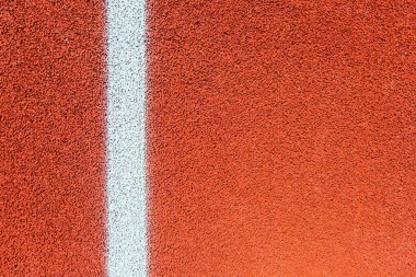 Koşu bandını yakın plan çekiyoruz. Spor sahasında beyaz çizgiler var. Spor temalı arka plan ve doku.