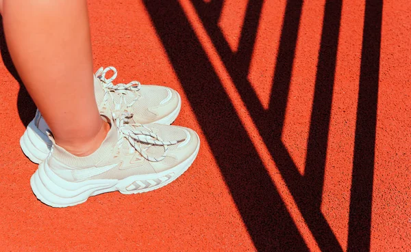 Жіночі Ноги Спортивному Взутті Стоять Спортивному Полі Червоне Покриття Штучного — стокове фото