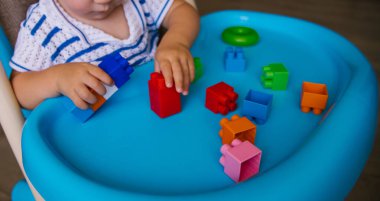 Çocuk çok renkli bir inşaatçı topluyor. Anaokulunda ya da evde çocuk dersleri. Çocukların gelişimi ve eğitimi.