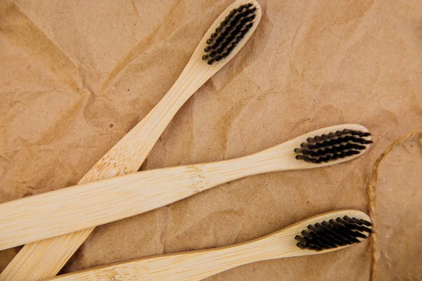 Tři Zubní Kartáčky Přírodního Bambusu Leží Kusu Dřeva Pozadí Hnědého — Stock fotografie
