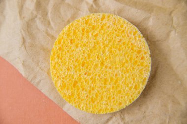 Kozmetik yuvarlak sünger. Süngerin gözenekli dokusu. Deriyi kozmetikten temizliyorum. Hijyen ve cilt bakımı.