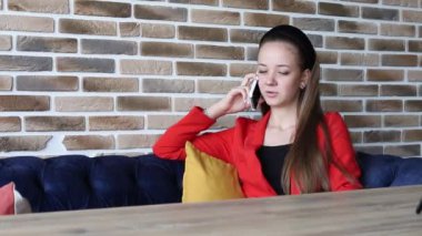 Genç bir kadın bir kafede oturuyor ve cep telefonuyla konuşuyor. Kız şık ve parlak bir şekilde giyinmiş. İş kadını iş konularını tartışır ya da arkadaşlarıyla konuşur.
