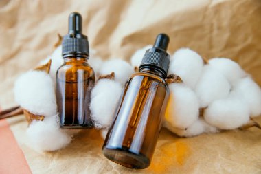 Aromaterapi kavramı, bir şişe gerekli yağ ve pamuk çiçekleriyle. Kaplıca ve bitkisel ilaçlar için durgun bir yaşam bileşimi. Cilt ve saç bakımı için kozmetik yağ..