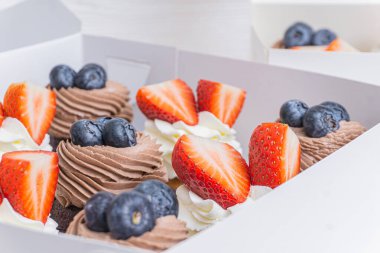 Beyaz bir kutuda bir dizi kek.