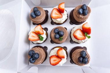 Beyaz bir kutuda bir dizi kek.