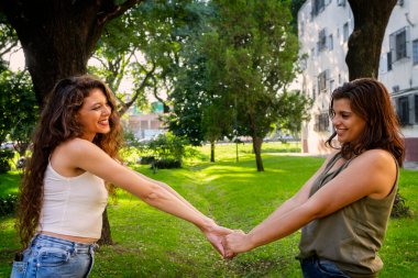 İki kadın ellerini tutuyor.