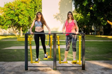 Hareketli kadınlar tam menzil adım, park arka planında hava yürüyüşü egzersiz eğitmeni kullanın