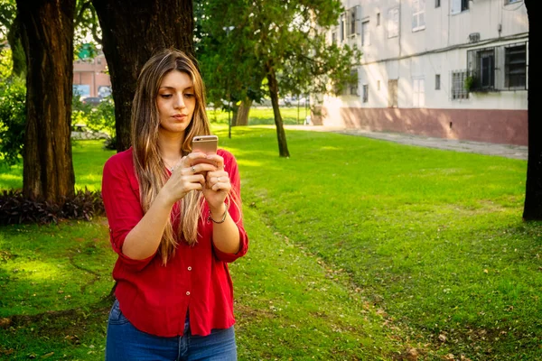 Ung Blond Kvinna Som Använder Mobiltelefon Parken — Stockfoto