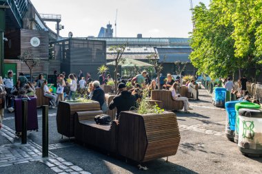 Londra, Birleşik Krallık - 16 Mayıs 2025: İnsanlar Londra 'nın ünlü Borough Market yakınlarındaki açık hava oturma alanında toplanıp sosyalleşiyorlar