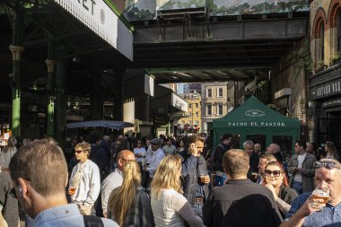 Borough Market 'te insanlar içiyor ve sosyalleşiyor.