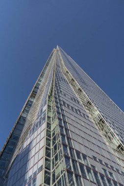 Londra, Birleşik Krallık - 16 Mayıs 2025: Açık mavi gökyüzüne karşı Shard gökdelenin yükselen cam cephesinin aşırı düşük açılı görünümü