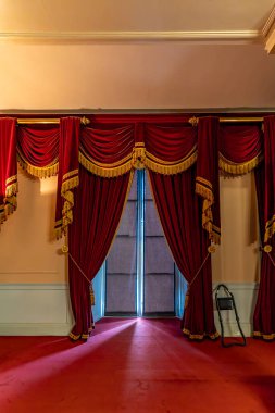 Londra, Birleşik Krallık - 18 Mayıs 2025: Kensington Sarayı 'nda süslü altın püsküllü zarif kırmızı kadife perdeler