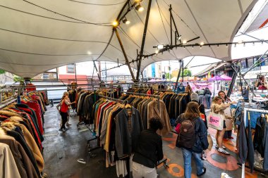 Londra, Birleşik Krallık - 18 Mayıs 2025: Müşteriler Portobello Green Market 'teki eski elbise raflarına göz atıyorlar