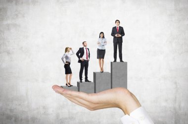 Bir kaideyi çubuk şeması şeklinde tutan bir el, üzerinde dört iş adamı duruyor. Ön görüş. Beton arka plan. Kariyer gelişimi kavramı.