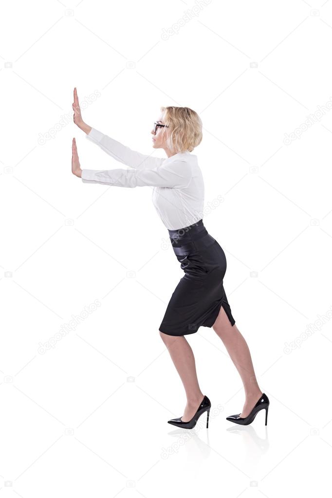 A businesswoman pushing an imaginary wall. Side view. Isolated. Concept of effort.