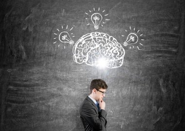 Brain and three bulbs drawn on black chalkboard.