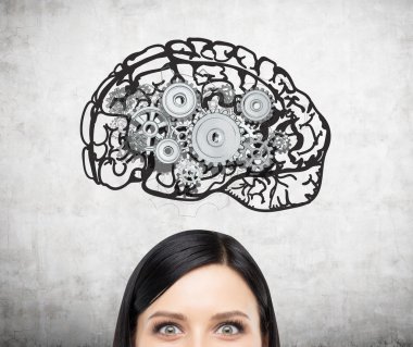 Image of brain with gears on concrete wall over woman's head