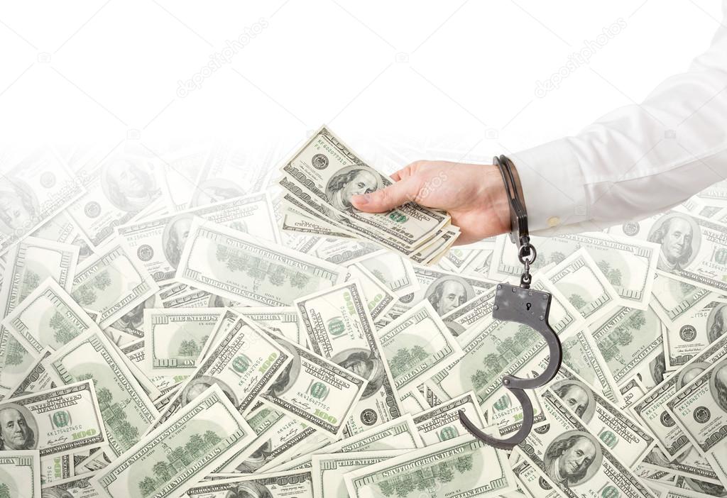 Hand with money in handcuffs