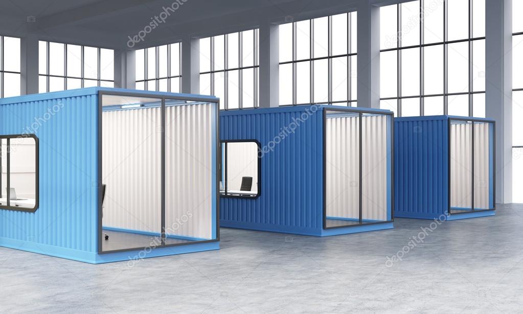 Three blue sea containers with offices inside.