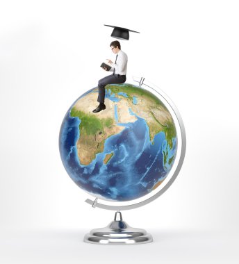 Man with book sitting on terrestrial globe