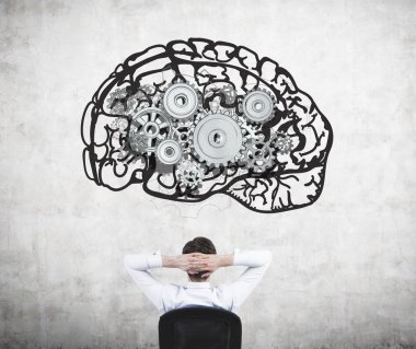 Businessman sitting on chair with hands on head and looking at image of brain with gears on concrete wall. clipart