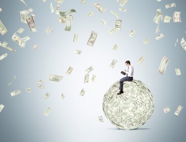 Man on dollar ball reading