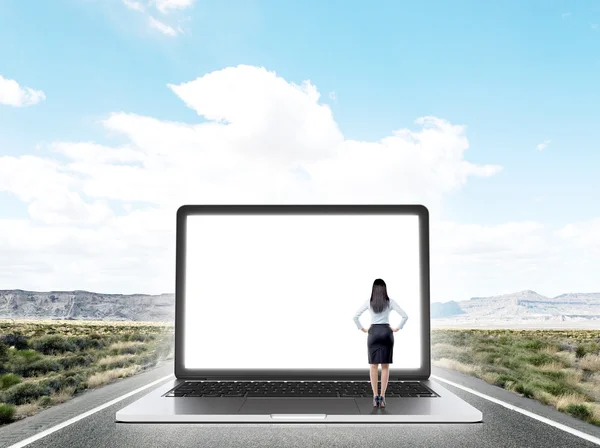 Donna d'affari in piedi sulla strada principale di fronte a schermo enorme del computer portatile con immagine di New York . — Foto Stock