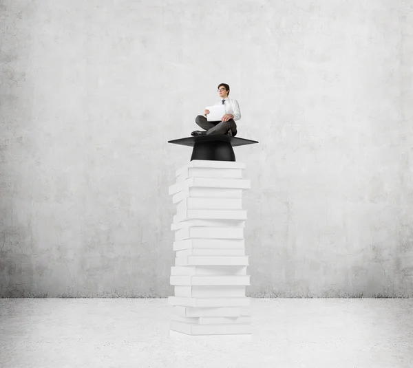 Geschäftsmann auf Bücherstapel — Stockfoto