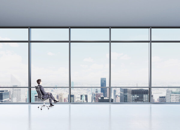 Businessman sitting on chair. Panoramic window with Paris view in front. Concept of thinking.