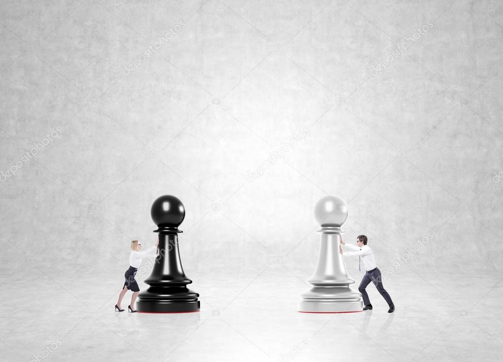 Businessman and businesswoman pushing black and white pawns to each other. Concrete background. Concept of business game.