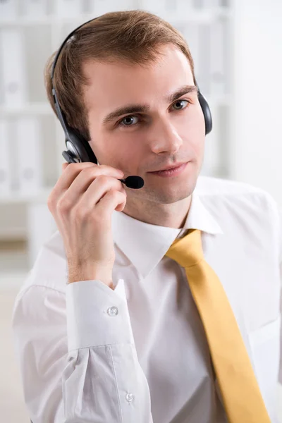 Geschäftsmann mit Kopfhörer und Mikrofon, der nach vorne schaut, Büro. Konzept der Kommunikation. — Stockfoto