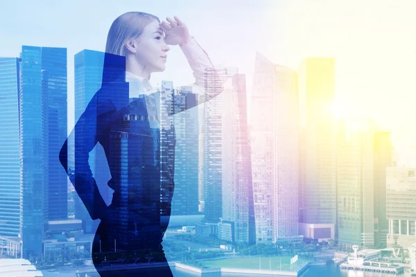 Businesswoman with hand at forehead, office buildings. — Stock Photo, Image