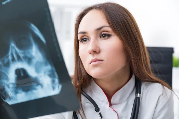 Female doctor looking at X-rays, close up. Light background. Concept of work. — Stock Photo, Image