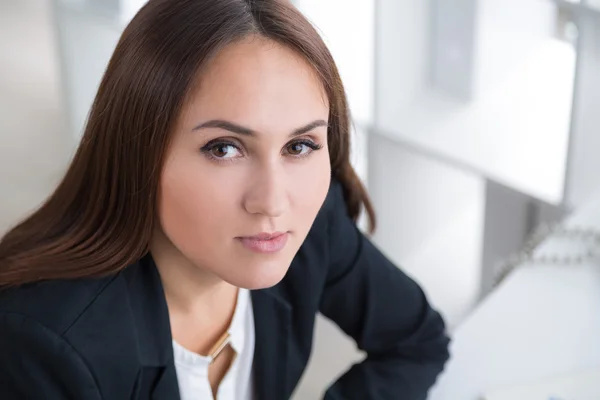 Donna d'affari seduta a tavola e che guarda in alto. Ritratto. In ufficio. Concetto di lavoro . — Foto Stock