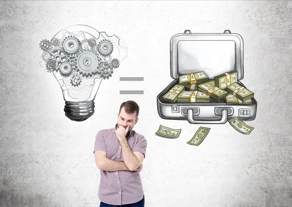 Человек с рукой на подбородке смотрит вверх, лампочка и открытый ящик с денежным уравнением нарисованы на бетонной стене позади. Концепция зарабатывания денег . — стоковое фото